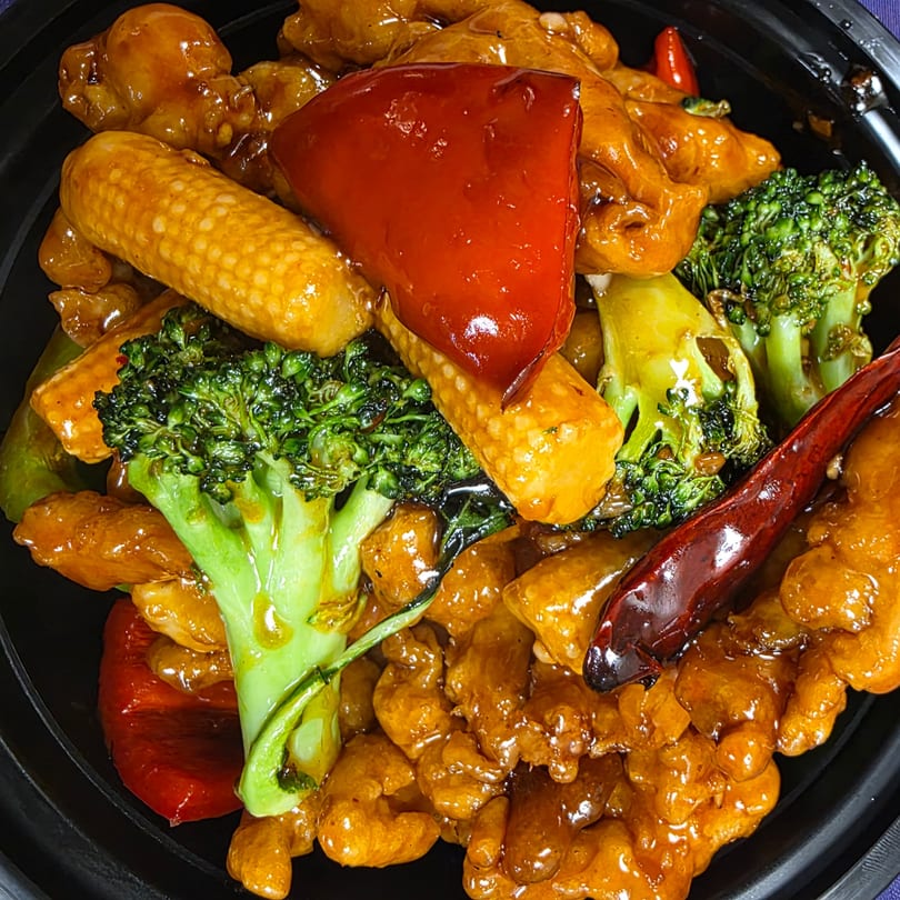 Close-up of China 10's General Tso's chicken with broccoli, baby corn, and red bell pepper.