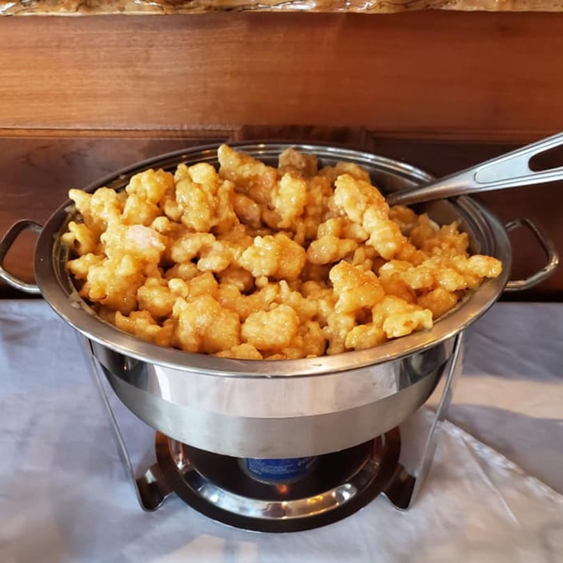 A chafing dish filled with golden-brown General Tso's chicken, ready to be served at China 10.